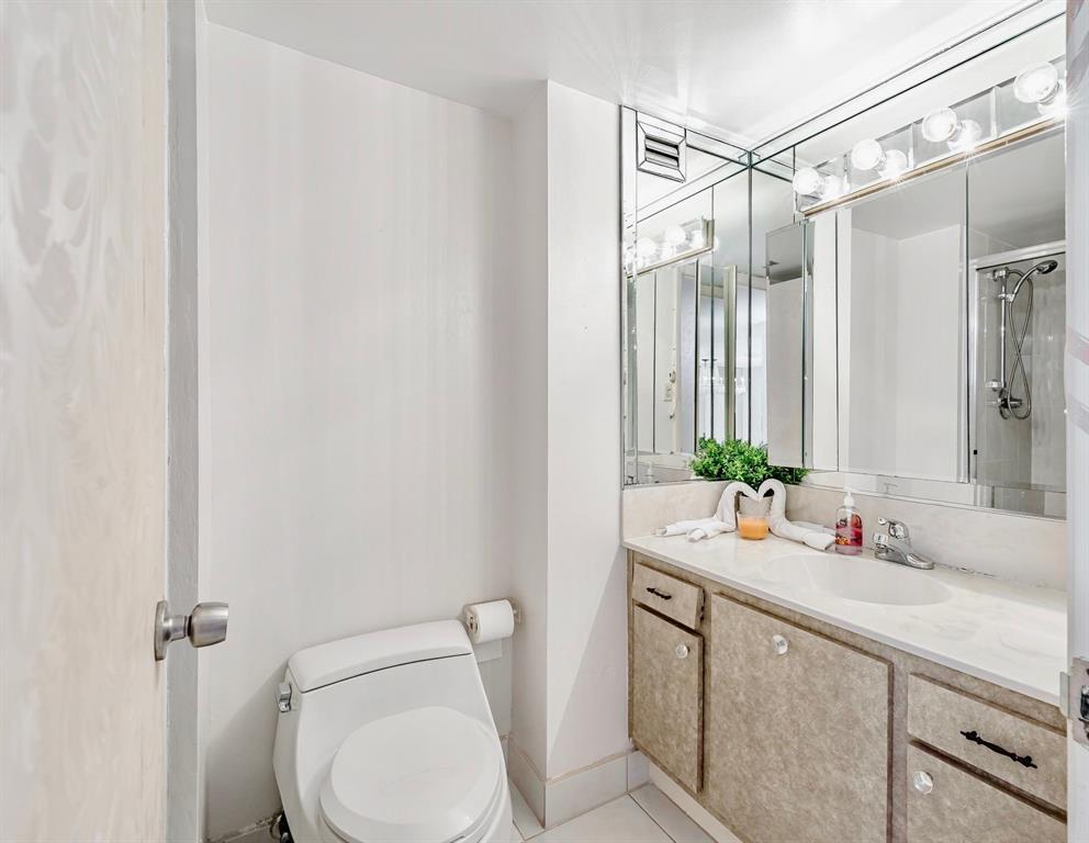 18031 Biscayne Boulevard, Unit 1104 Aventura, FL 33160 - Photo 12 of 35 a bathroom with a granite countertop sink mirror vanity and toilet