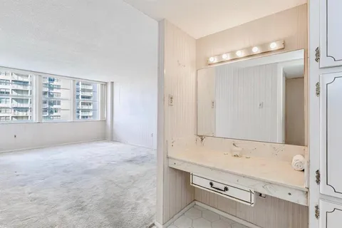 a bathroom with a granite countertop sink mirror and a bathtub