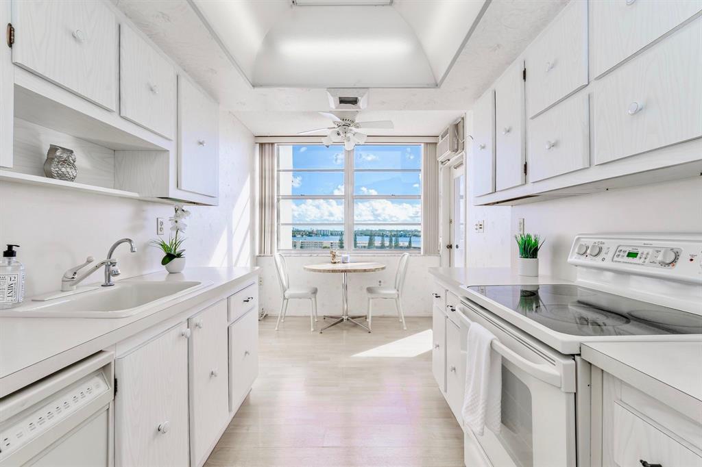 18031 Biscayne Boulevard, Unit 1104 Aventura, FL 33160 - Photo 4 of 35 a kitchen with a sink stove and cabinets