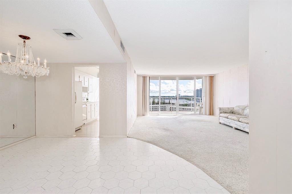 18031 Biscayne Boulevard, Unit 1104 Aventura, FL 33160 - Photo 6 of 35 an empty room with chandelier fan and windows