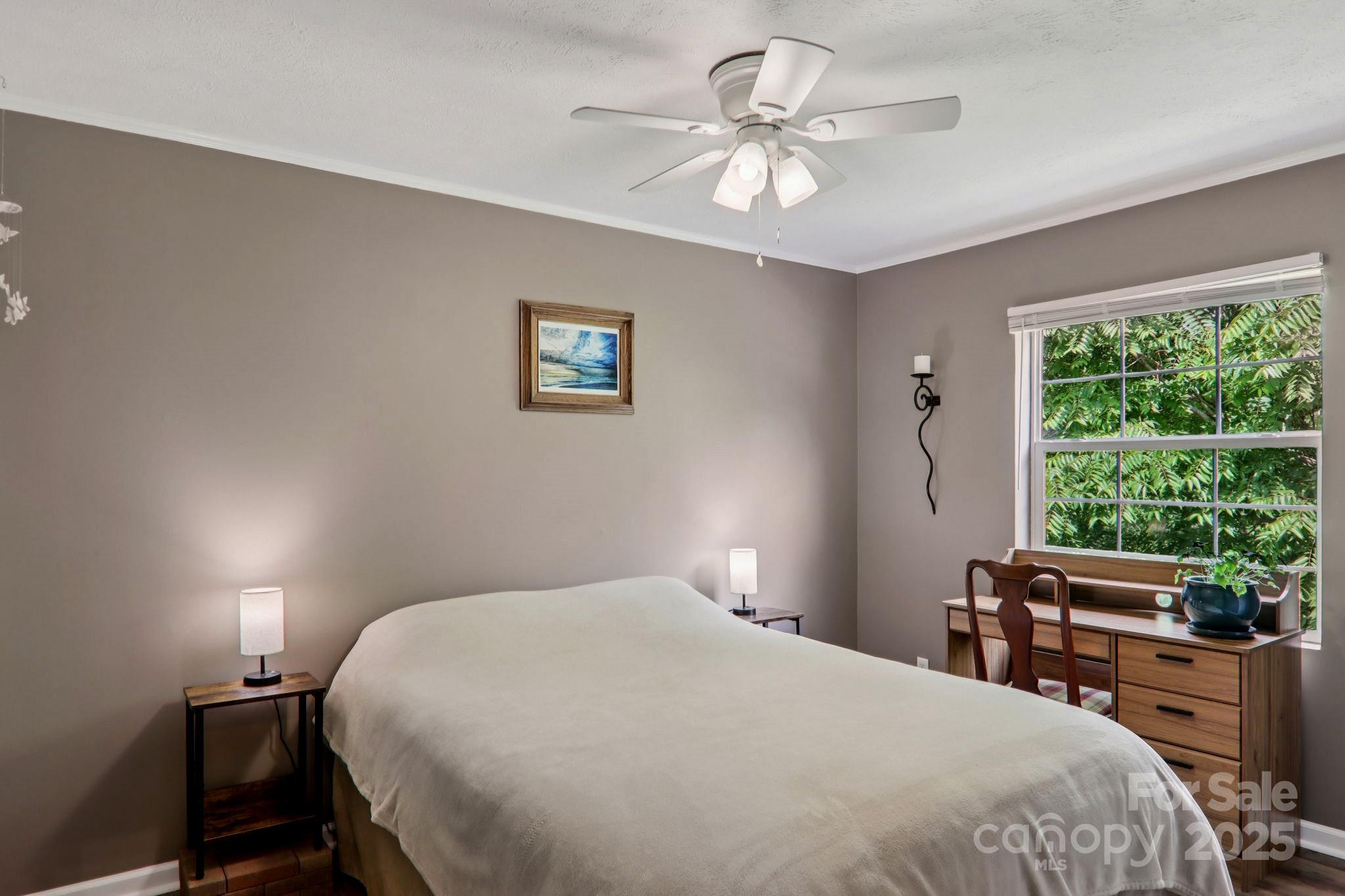 1282 Spicer Cove Road Hendersonville, NC 28792 - Photo 21 of 42 a bedroom with a large bed and a chandelier