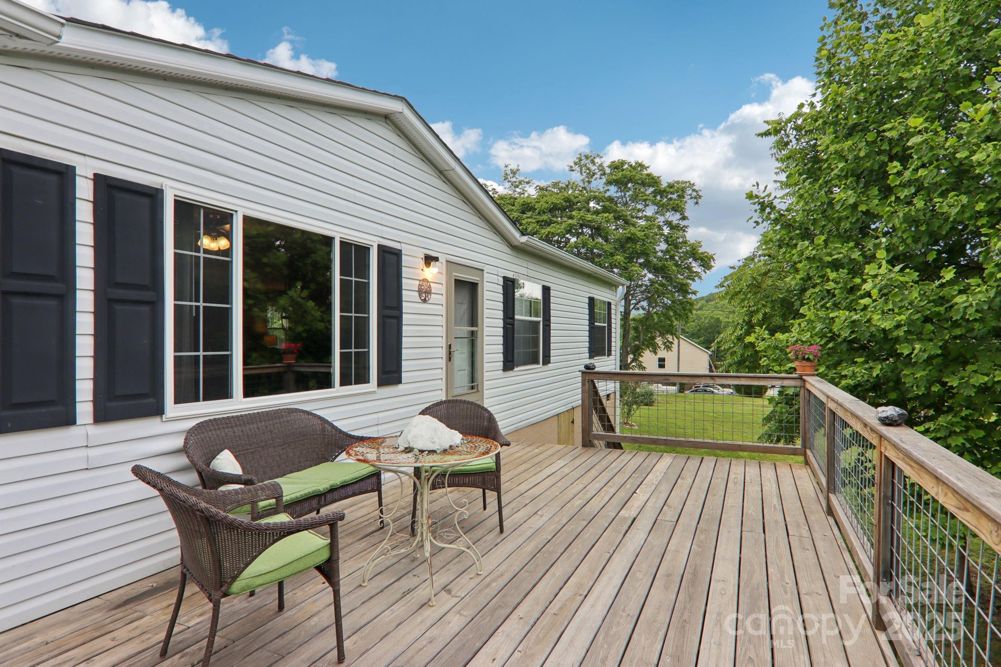 1282 Spicer Cove Road Hendersonville, NC 28792 - Photo 27 of 42 a balcony with wooden floor and outdoor seating