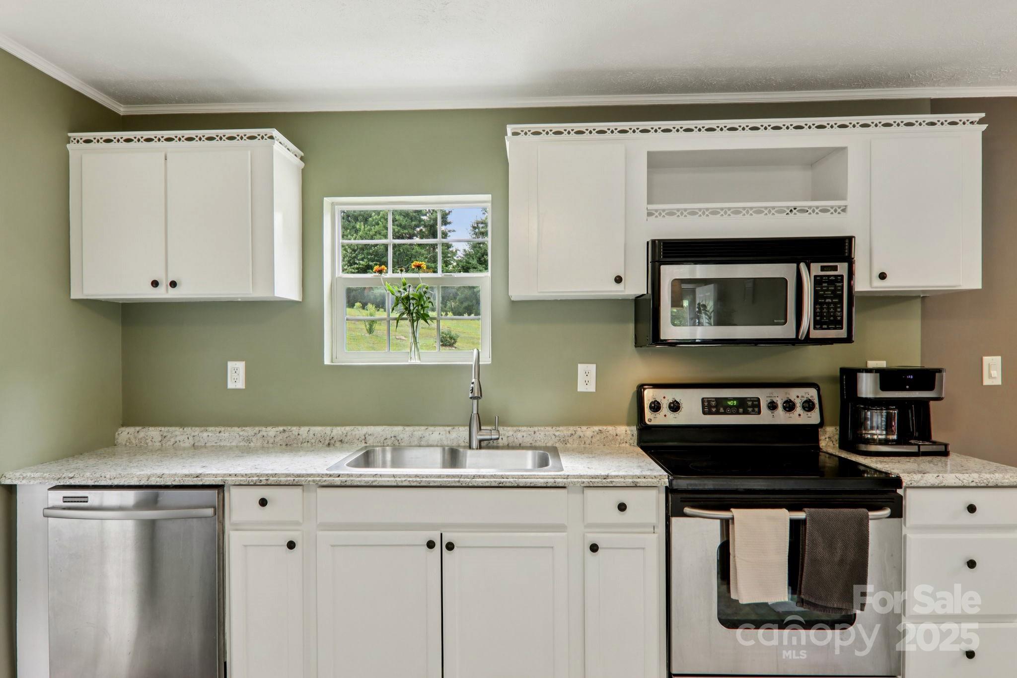1282 Spicer Cove Road Hendersonville, NC 28792 - Photo 7 of 42 a kitchen with granite countertop a stove a sink and a microwave