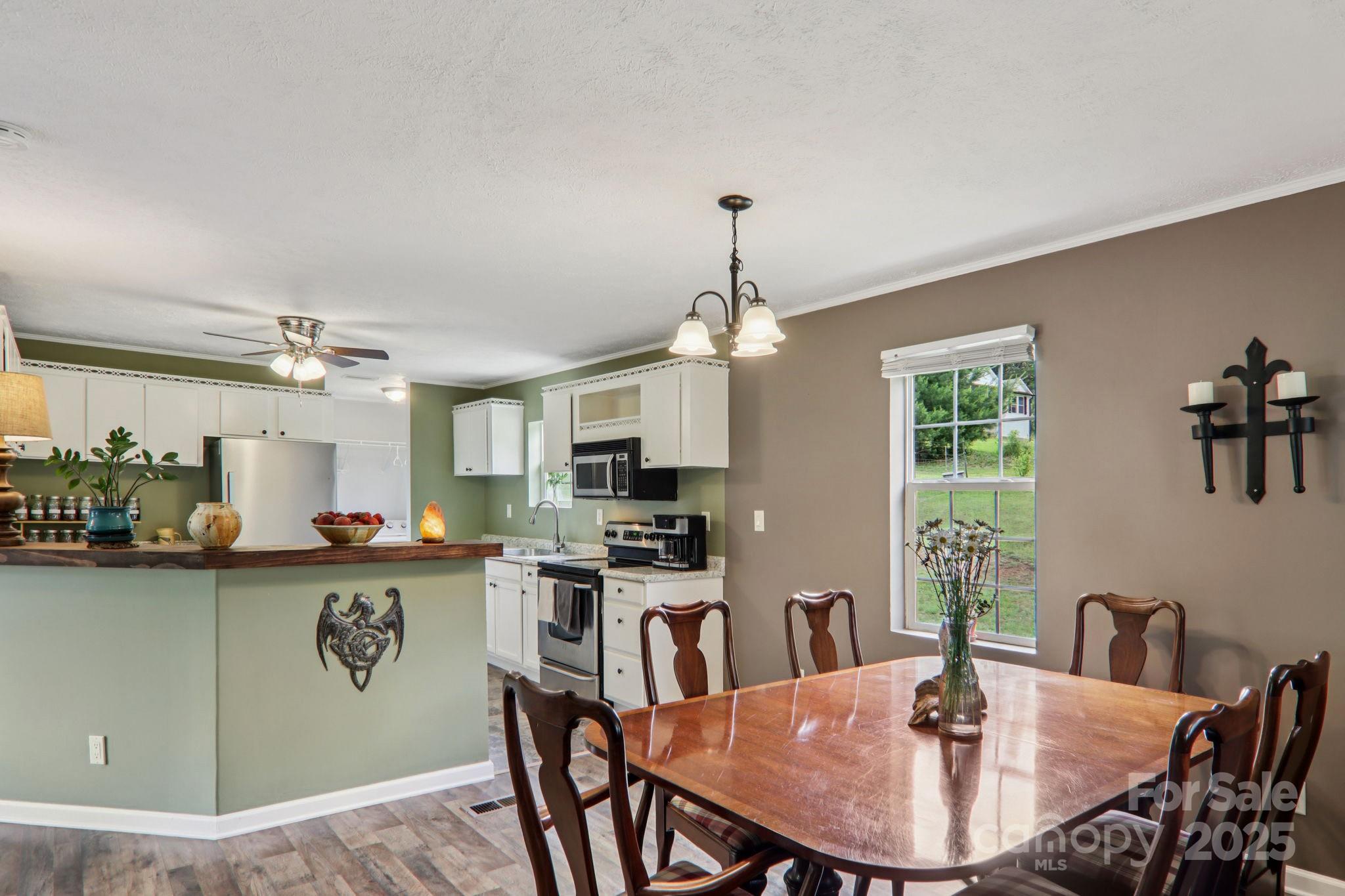 1282 Spicer Cove Road Hendersonville, NC 28792 - Photo 9 of 42 a kitchen with stainless steel appliances granite countertop a dining table and chairs with wooden floor