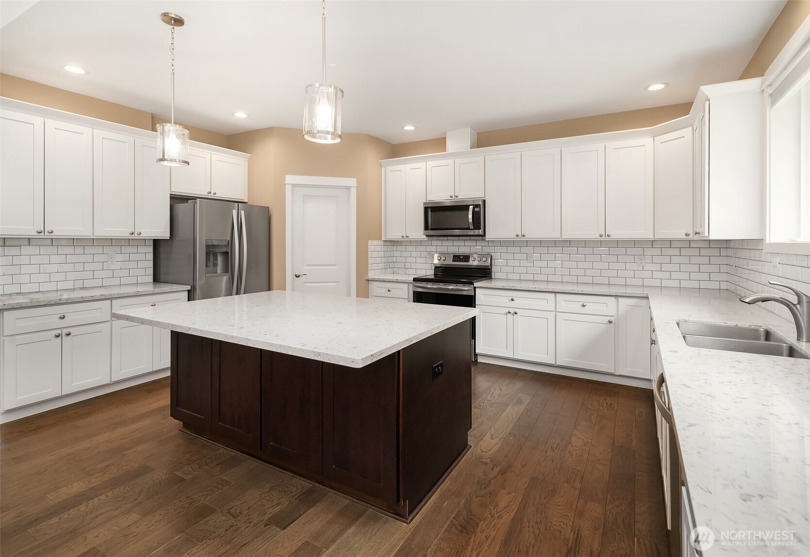 216 Cornwall Road Northwest Lakebay, WA 98349 - Photo 14 of 34 a kitchen with kitchen island granite countertop a sink a stove top oven a refrigerator cabinets and wooden floor