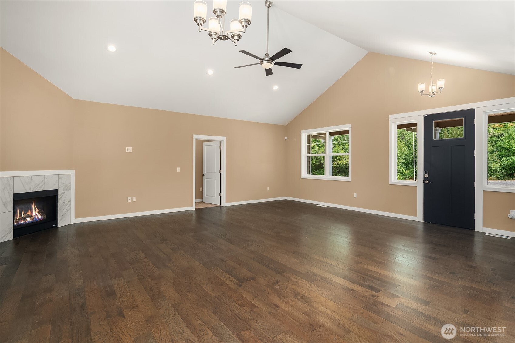 216 Cornwall Road Northwest Lakebay, WA 98349 - Photo 21 of 34 an empty room with wooden floor fireplace and windows