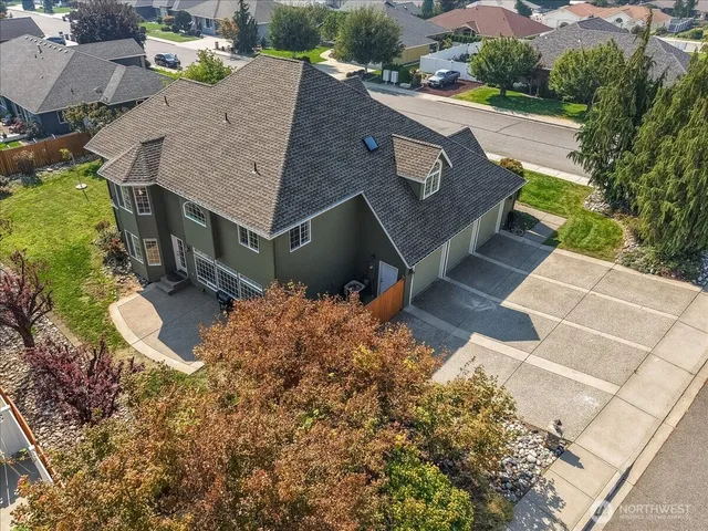 an aerial view of a house with yard and mountain view in back
