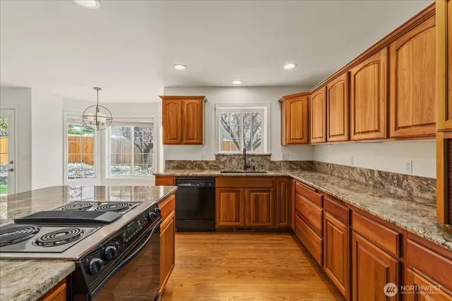 a kitchen with stainless steel appliances granite countertop a stove a sink dishwasher and a microwave