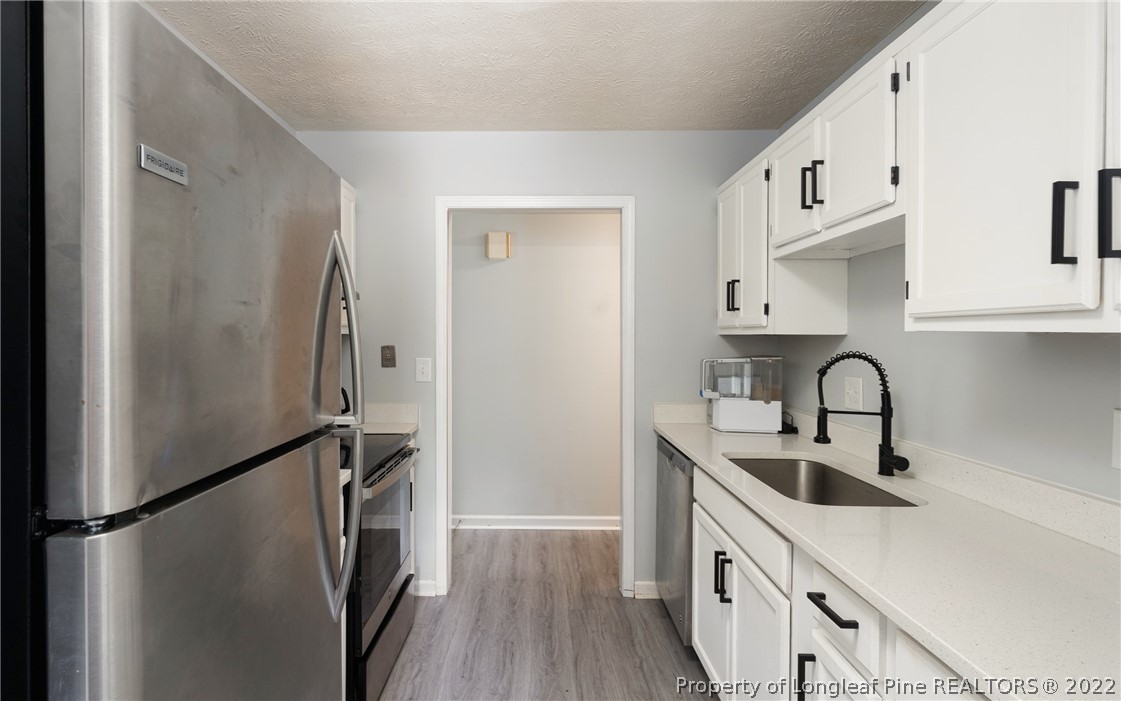 1742 Rim Road Fayetteville, NC 28314 - Photo 14 of 21 a kitchen with stainless steel appliances a refrigerator a sink a stove and cabinets