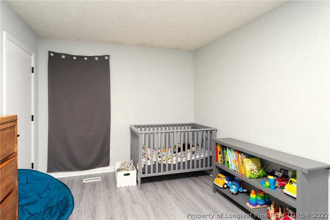 1742 Rim Road Fayetteville, NC 28314 - Photo 17 of 21 a bedroom with a bed and a wooden floor
