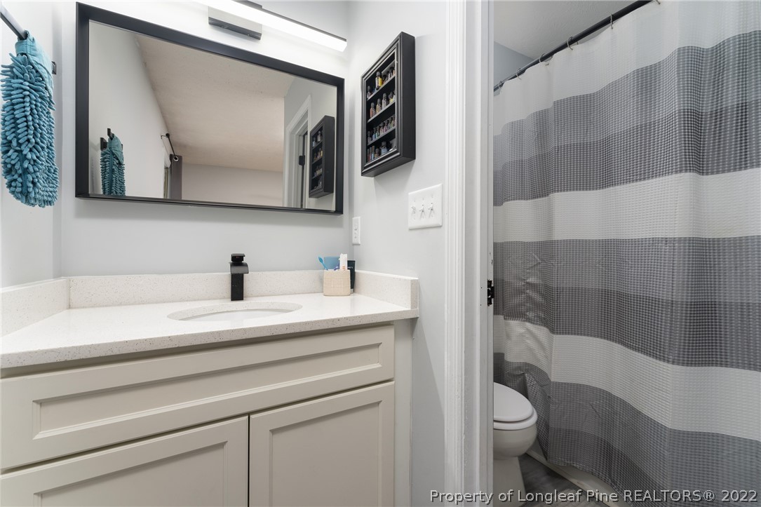 1742 Rim Road Fayetteville, NC 28314 - Photo 21 of 21 a bathroom with a toilet a sink and mirror