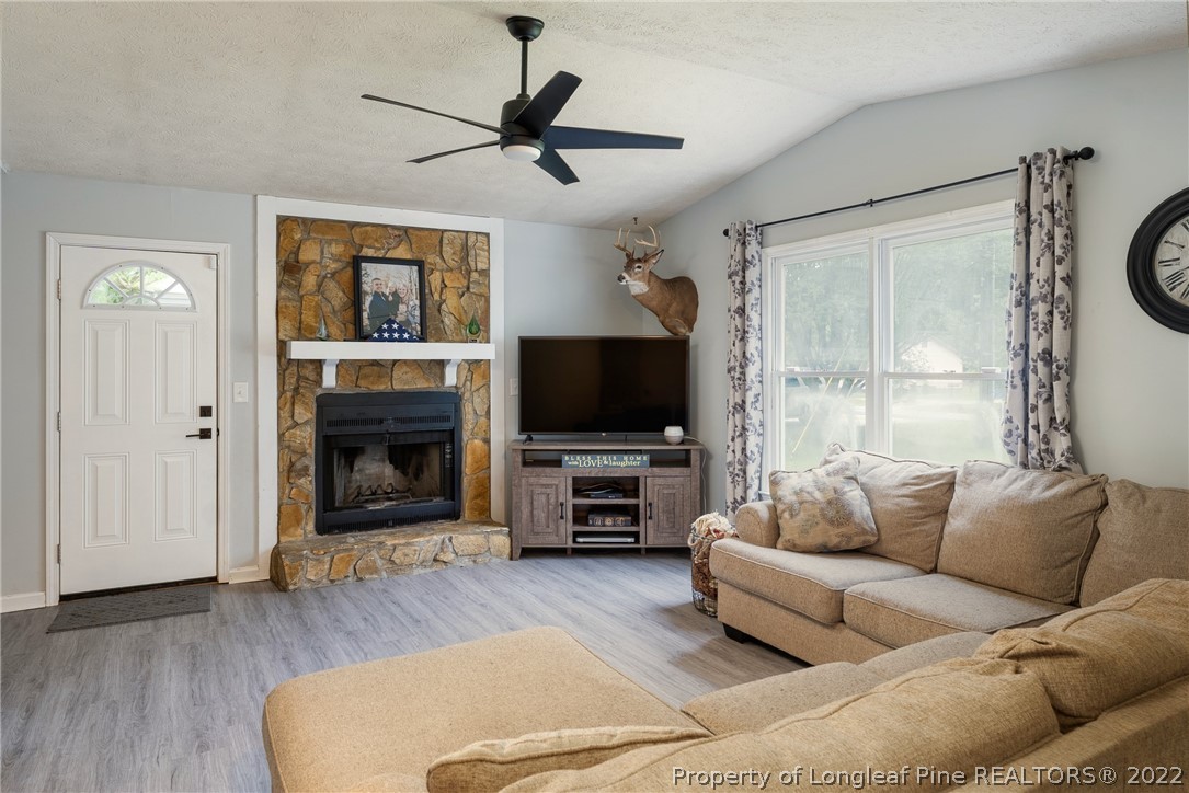 1742 Rim Road Fayetteville, NC 28314 - Photo 10 of 21 a living room with furniture a flat screen tv and a fireplace