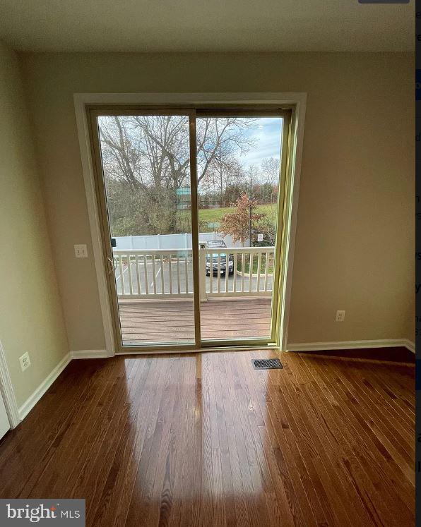 43855 Stubble Cor Square Ashburn, VA 20147 - Photo 9 of 38 a view of an empty room with wooden floor and a window