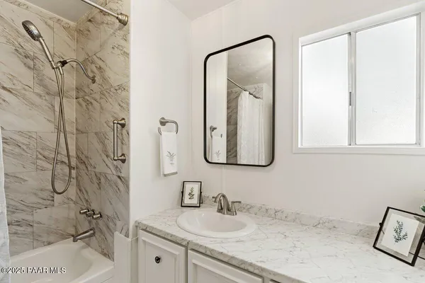 a bathroom with a granite countertop sink and a mirror