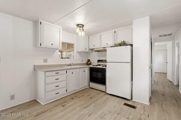 a kitchen with white cabinets and white appliances