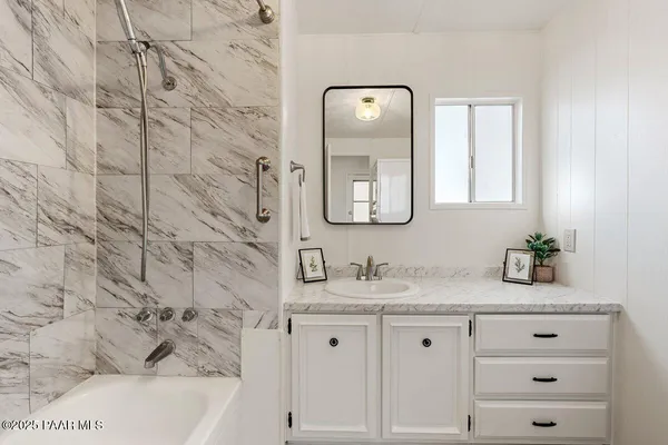 a bathroom with a sink vanity and mirror