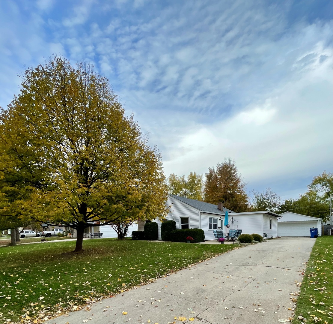 a view of a house with a big yard and large trees