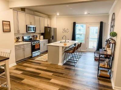 1346 Rosepine Drive Cary, NC 27519 - Photo 9 of 28 a living room with stainless steel appliances furniture a flat screen tv and a refrigerator