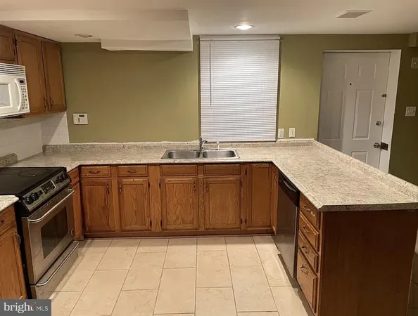 a kitchen with a sink a stove top oven and cabinetry