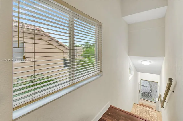 a living room with furniture potted plant and a large window