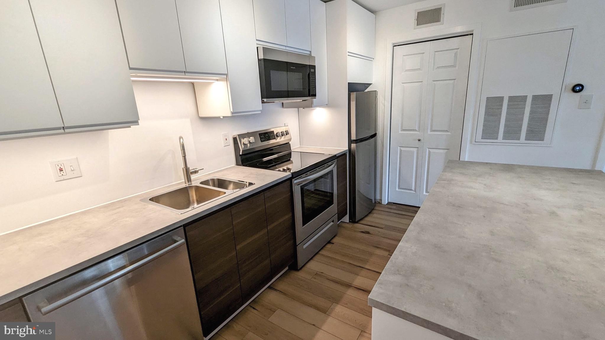 a kitchen with stainless steel appliances a sink dishwasher stove and refrigerator