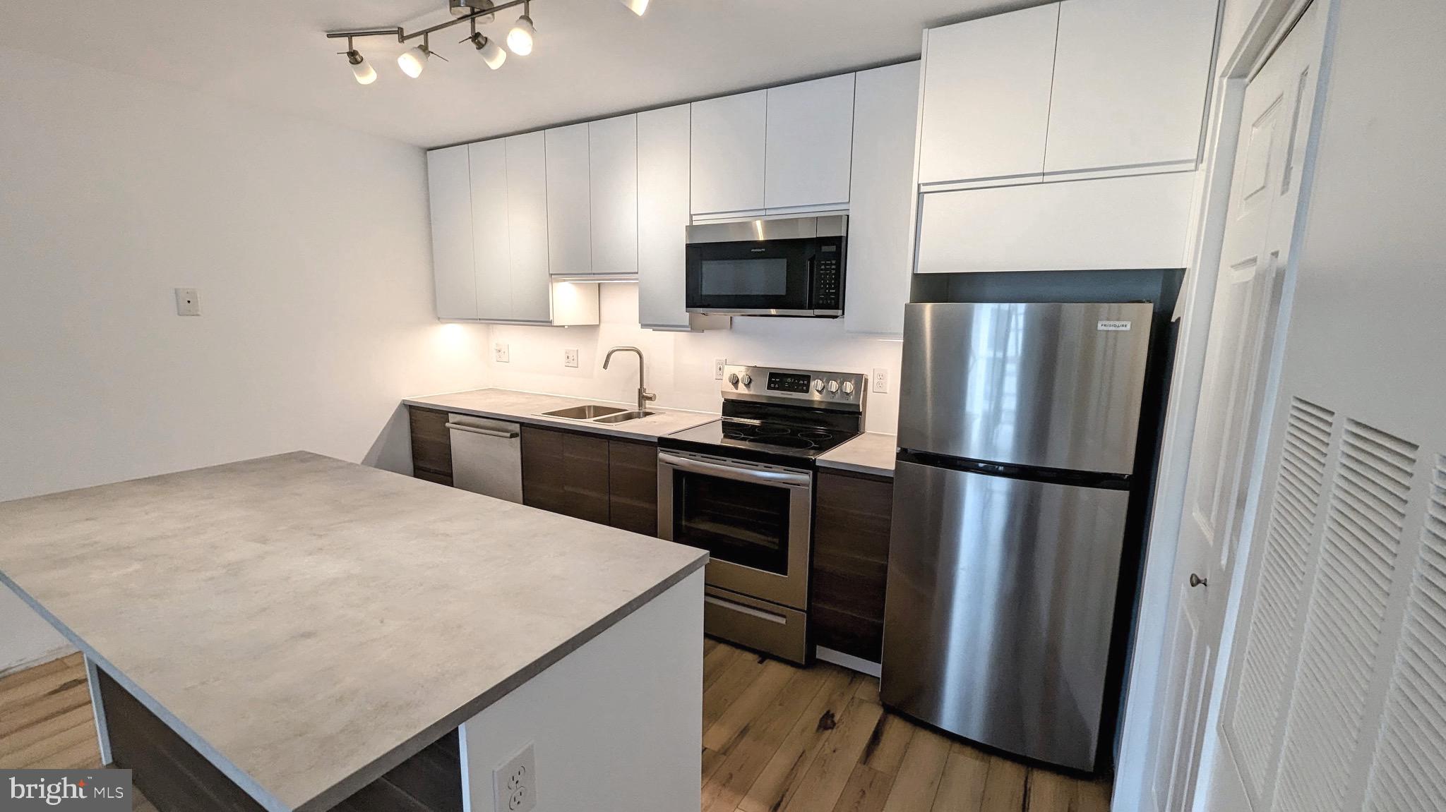 3310 Wyndham Circle, Unit 314 Alexandria, VA 22302 - Photo 2 of 31 a kitchen with stainless steel appliances a refrigerator stove microwave and sink