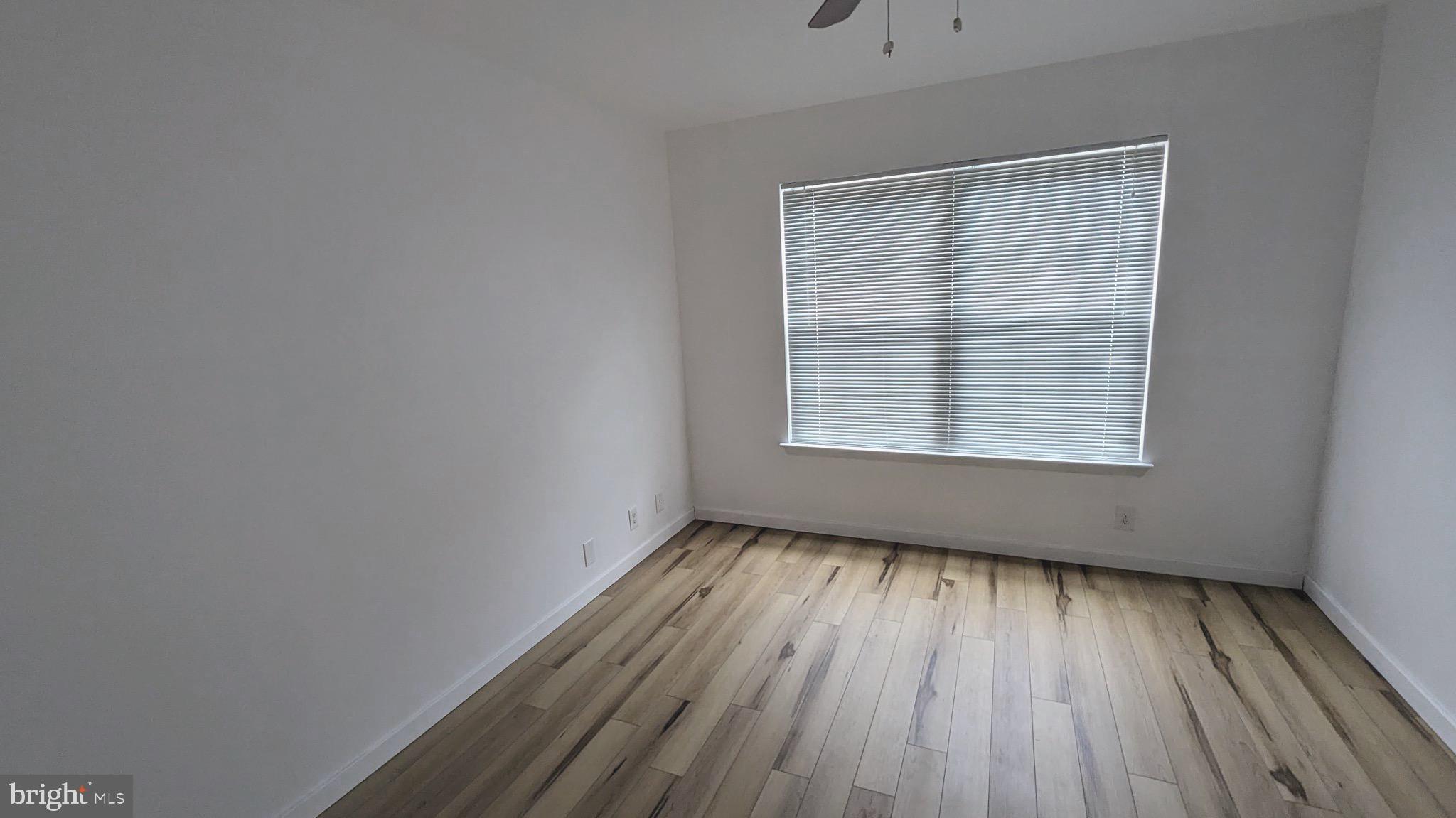 3310 Wyndham Circle, Unit 314 Alexandria, VA 22302 - Photo 6 of 31 an empty room with wooden floor and windows
