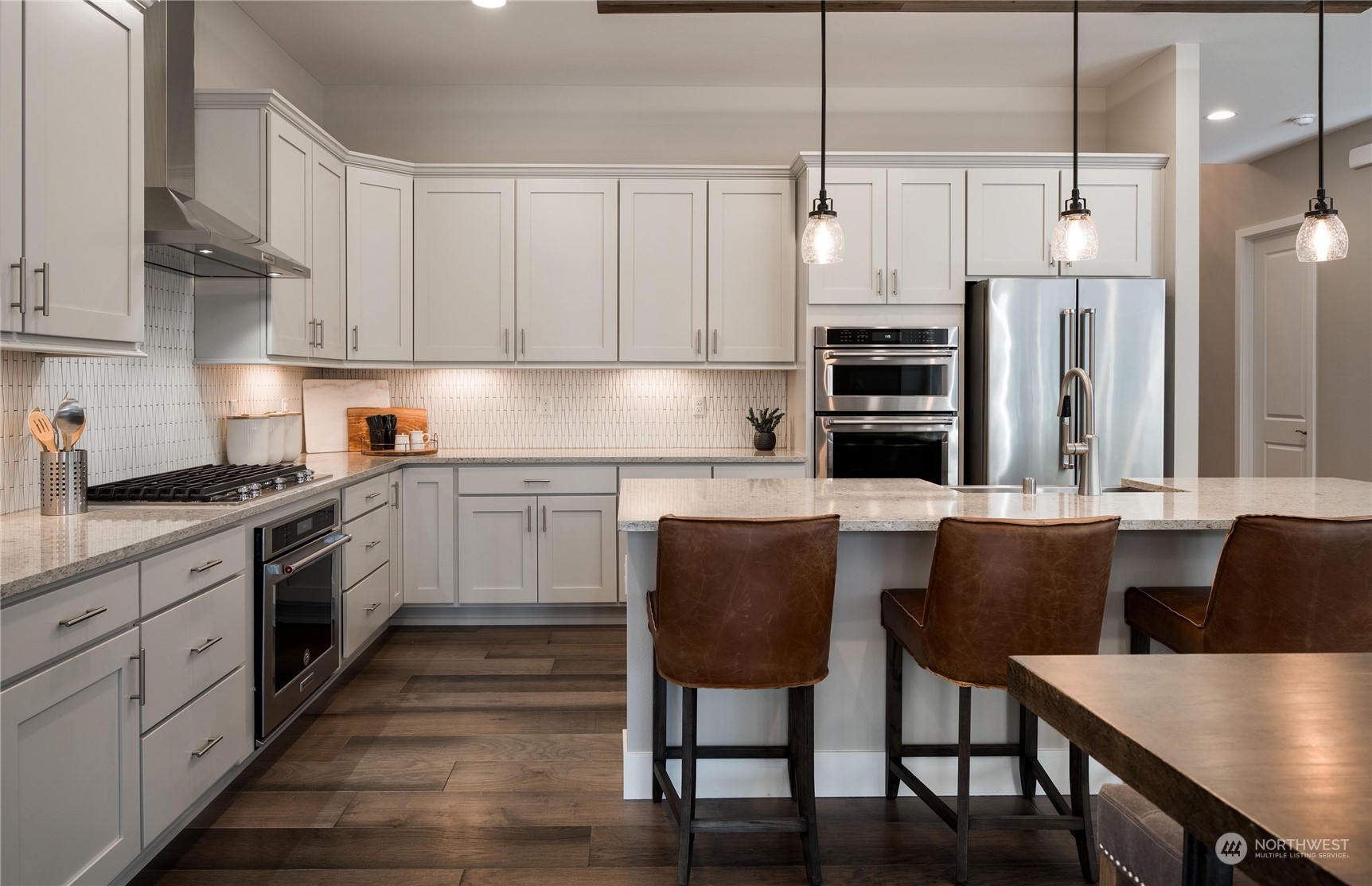 3906 Northeast 27th Place, Unit 2 Renton, WA 98056 - Photo 3 of 18 a kitchen with a table chairs sink and cabinets