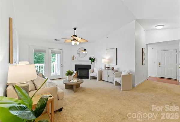 a living room with furniture a fireplace and a chandelier