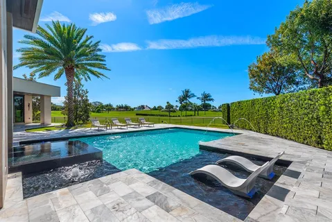 a view of a house with backyard and parking area