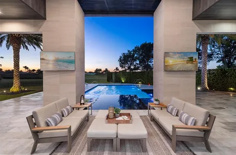 a living room with furniture kitchen view and a large window