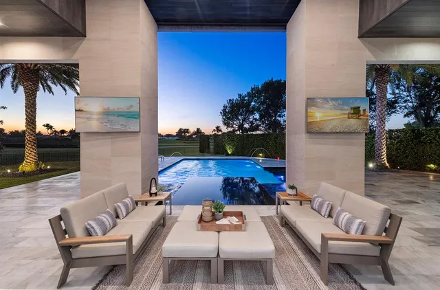 a living room with furniture kitchen view and a large window