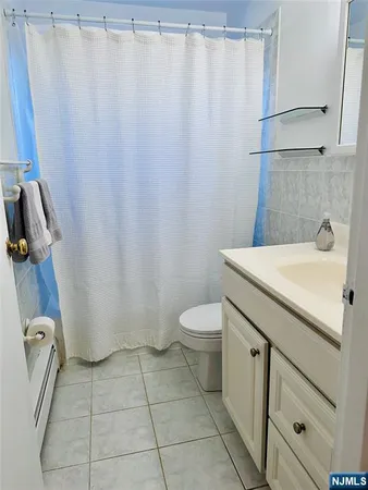 a bathroom with a sink a toilet a mirror and shower curtain