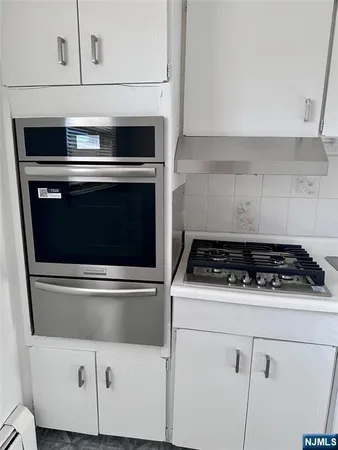 a stove top oven sitting inside of a kitchen