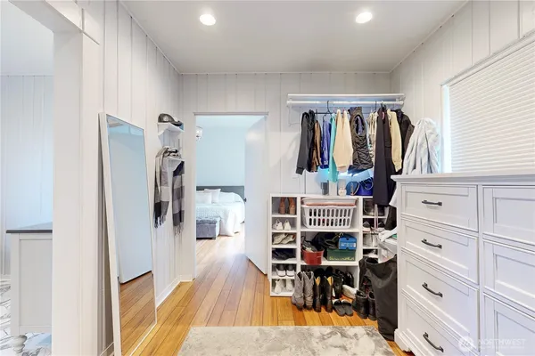 a view of walk in closet with clothes and shoes