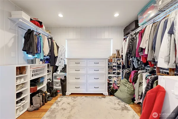 a view of walk in closet with clothes and shoes