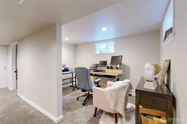 a view of a workspace with furniture and a window