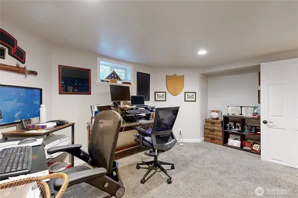 a view of a workspace with furniture and a window