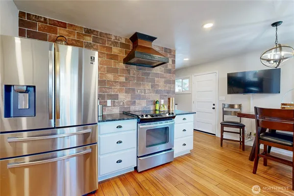 a kitchen with stainless steel appliances granite countertop a refrigerator and a stove top oven