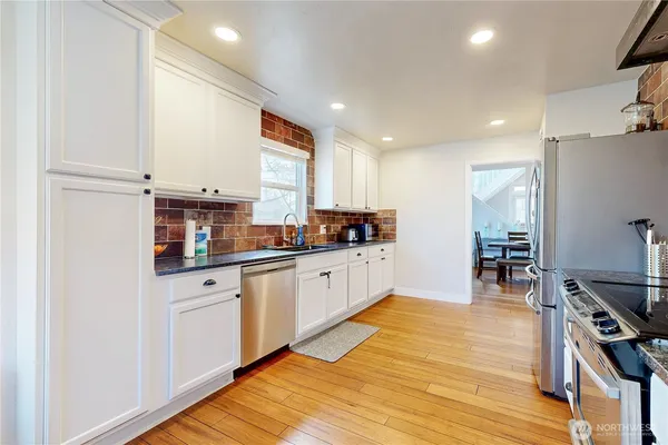 a kitchen with stainless steel appliances granite countertop a stove and a refrigerator