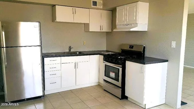 a kitchen with white cabinets and white appliances