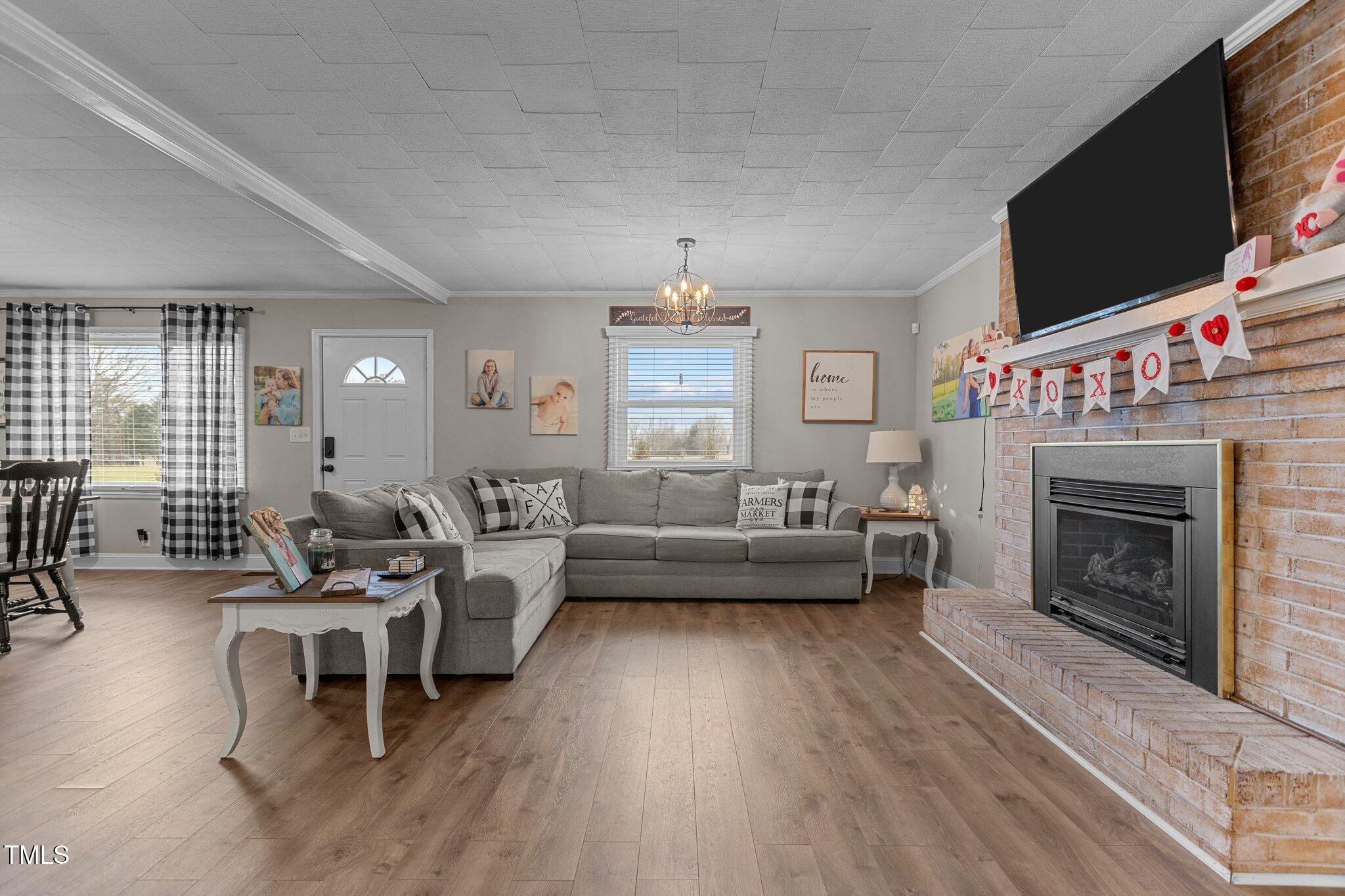 2144 Blalock Dairy Road Roxboro, NC 27574 - Photo 13 of 42 a living room with furniture a flat screen tv and a fireplace
