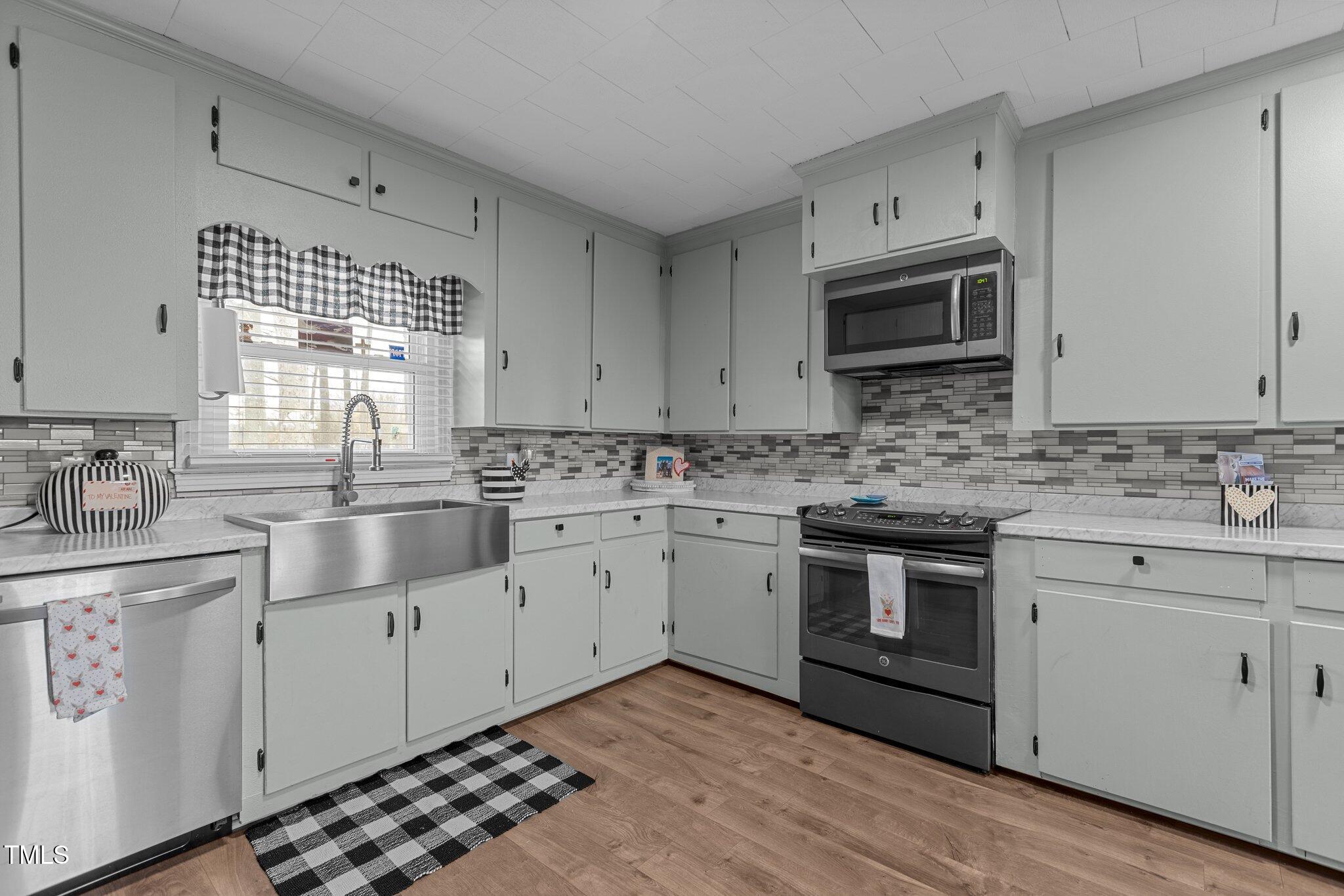 2144 Blalock Dairy Road Roxboro, NC 27574 - Photo 20 of 42 a kitchen with stainless steel appliances white cabinets a sink and a stove