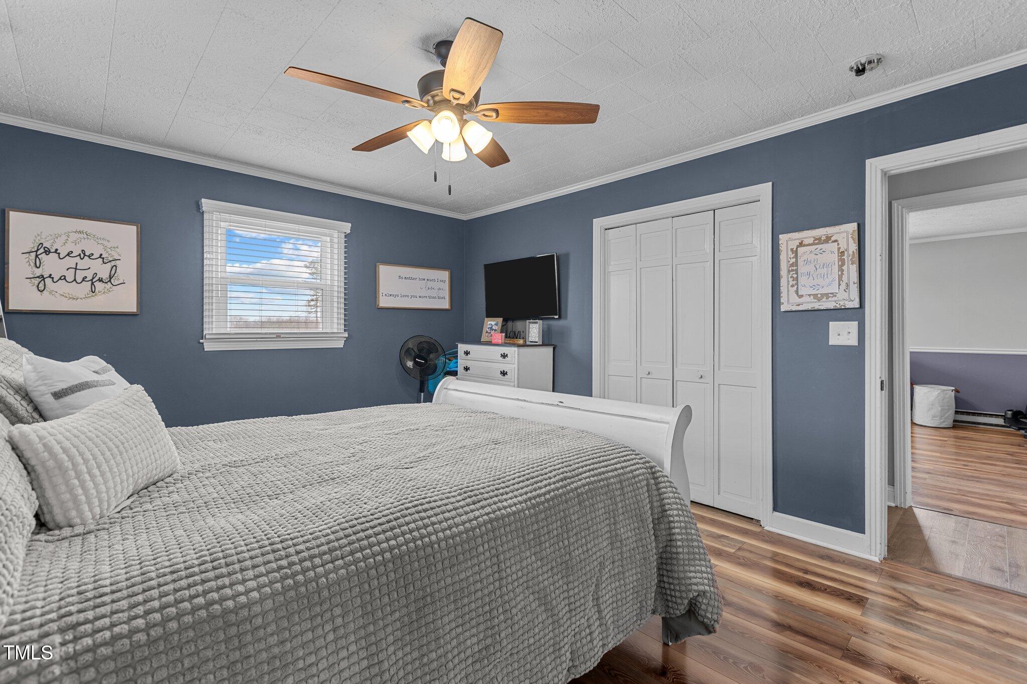 2144 Blalock Dairy Road Roxboro, NC 27574 - Photo 26 of 42 a bedroom with a large bed and a chandelier