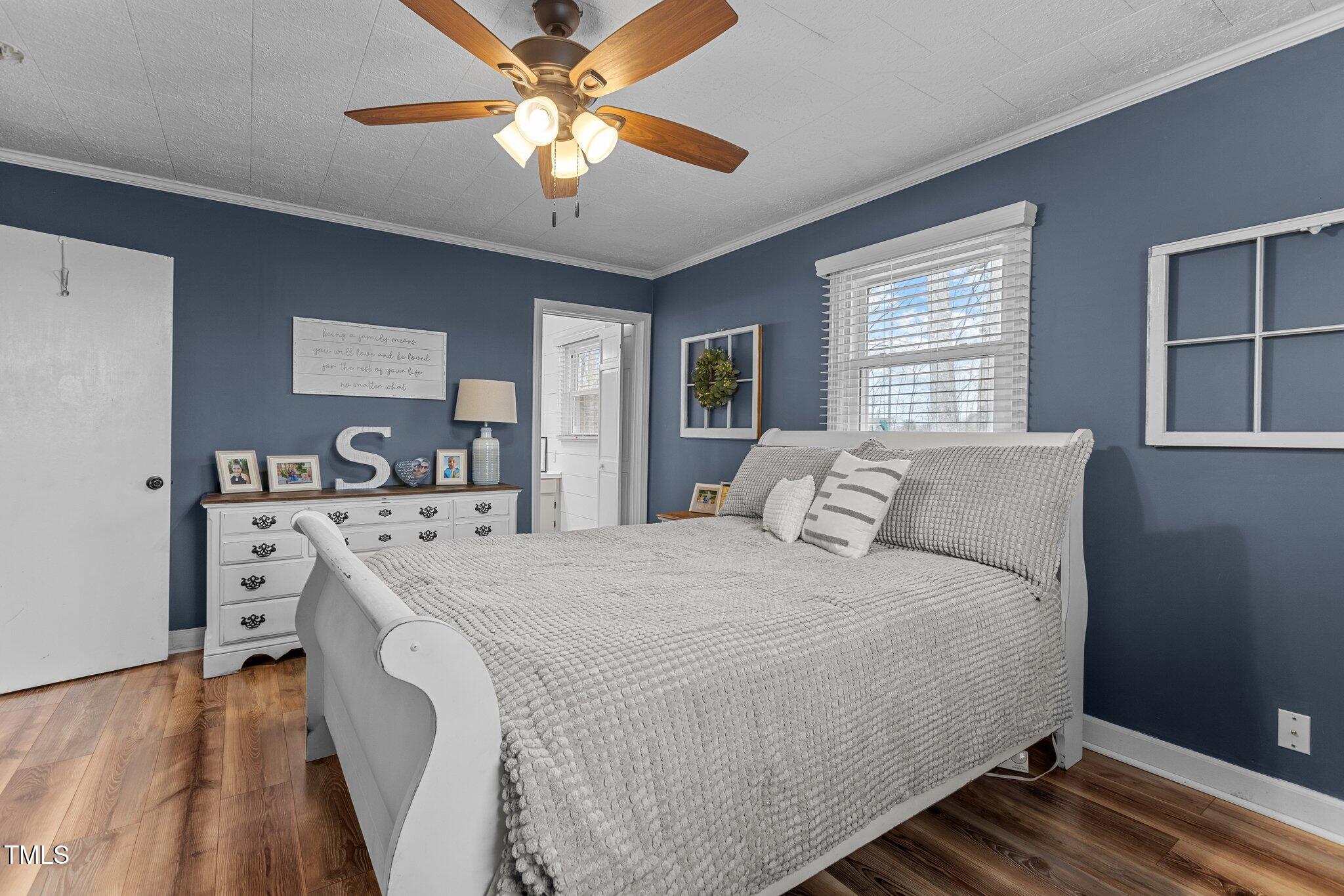 2144 Blalock Dairy Road Roxboro, NC 27574 - Photo 27 of 42 a spacious bedroom with a bed and a chandelier