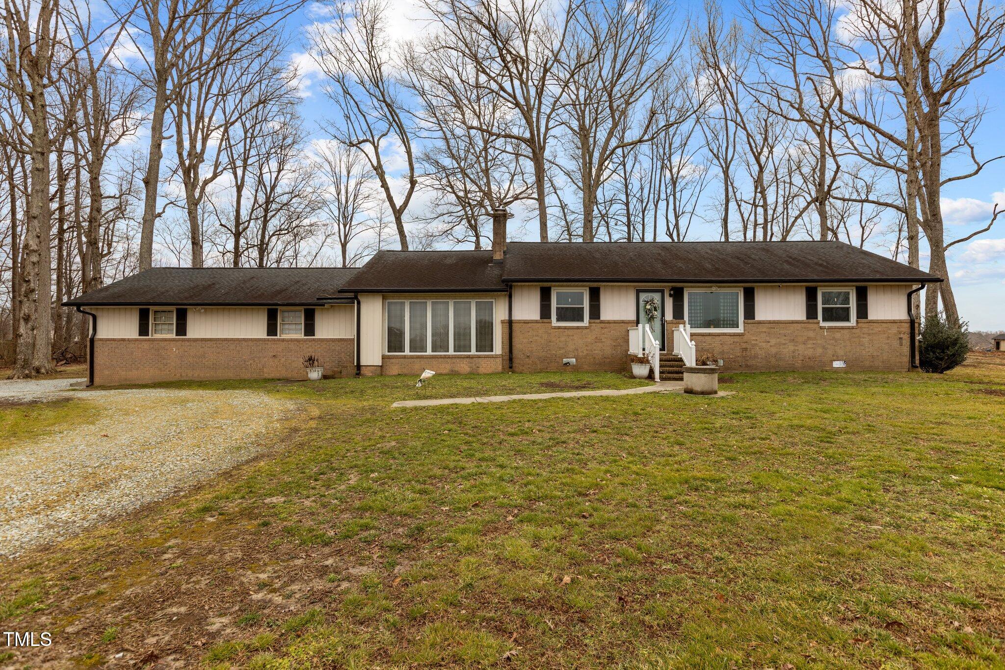 2144 Blalock Dairy Road Roxboro, NC 27574 - Photo 2 of 42 a front view of a house with a yard table and chairs