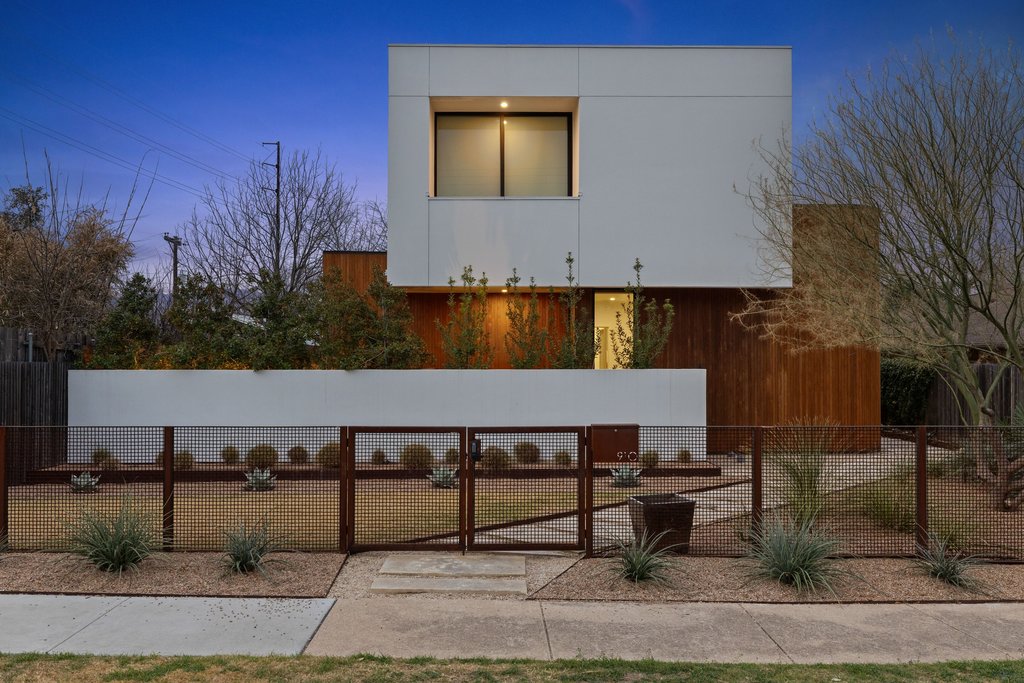 View of side of property featuring a fenced front yard, a gate, and stucco siding