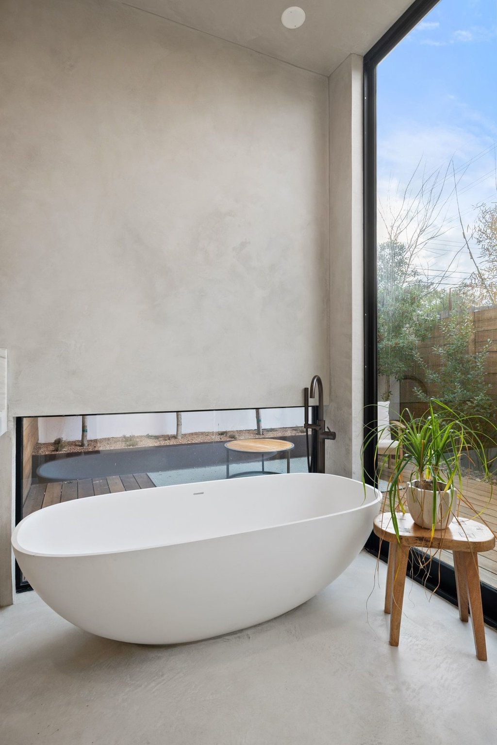 910 West Johanna Street Austin, TX 78704 - Photo 16 of 37 Bathroom featuring expansive windows, a freestanding bath, and finished concrete floors