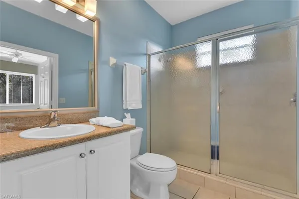 a bathroom with a granite countertop sink toilet and shower