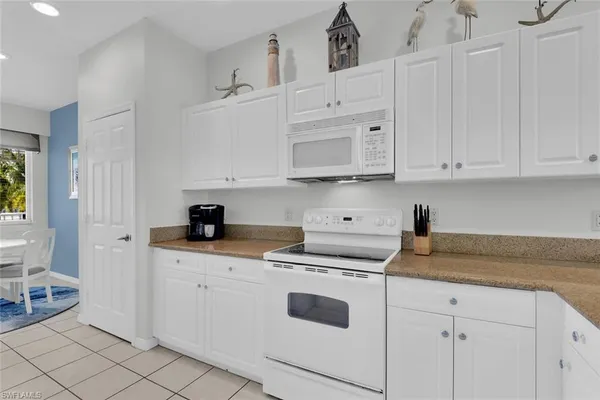 a kitchen with stainless steel appliances granite countertop white cabinets sink and dishwasher